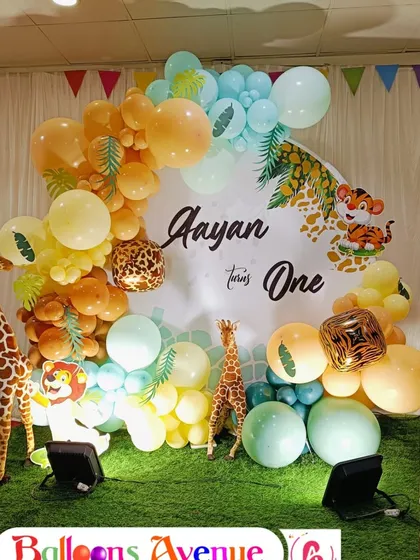 A focused shot on the central backdrop and balloon arrangement for the jungle theme. The mix of orange, yellow, and teal balloons complements the friendly animal graphics.