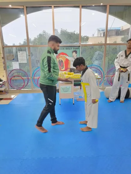 A young student bows after receiving his yellow belt.
