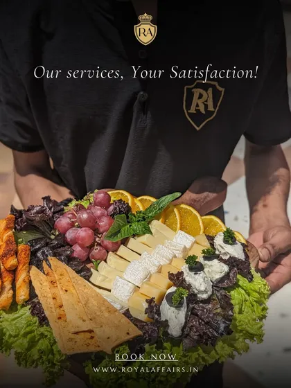 My commitment is to your satisfaction, delivered on a platter. A member of my professional staff presents a beautifully arranged cheese and fruit platter, showcasing the quality of ingredients and attention to detail I bring to every event.