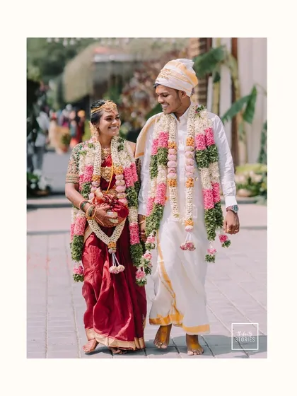 A joyful walk together after the ceremony, hand in hand. The bride's radiant smile and the groom's happy glance perfectly capture the bliss of a South Indian wedding celebration.
