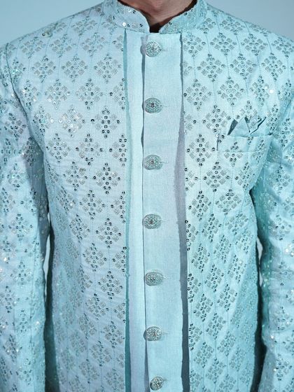 A close-up of the light blue sherwani, highlighting the intricate silver embroidery and elegant buttons.