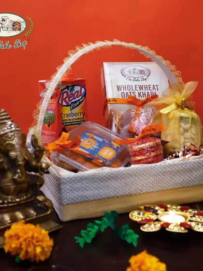 A beautifully arranged Diwali hamper, combining sweet and savoury treats like khari, cookies, and juice for a complete festive gift.