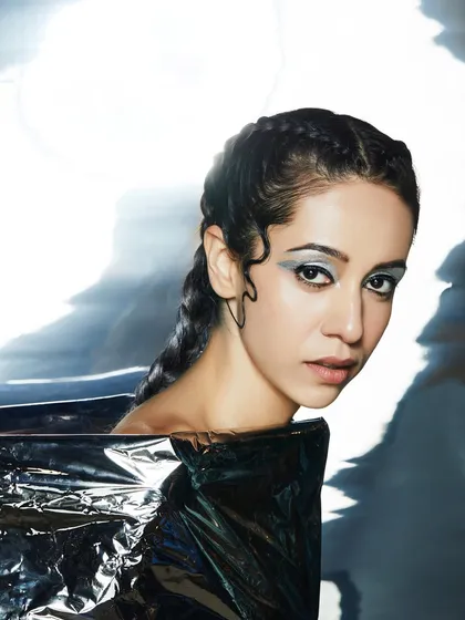 A futuristic look with a silver graphic eye and braided hair, showcasing a modern and edgy aesthetic.