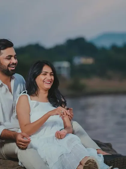 Candid laughter and joy shared by a couple during their pre-wedding shoot by the lake.