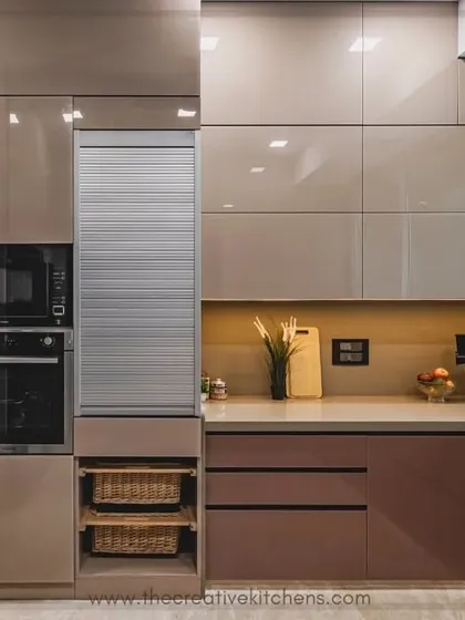 A detailed shot of our quality craftsmanship. This kitchen features integrated appliances and a roller shutter unit, all seamlessly built into the high-gloss cabinetry for a clean, uncluttered look that maximizes both style and utility.