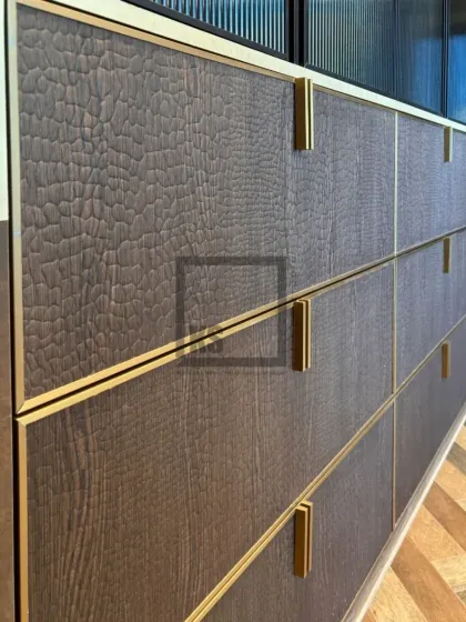 The details are what make a design exceptional. This close-up shows a custom drawer with a textured, leather-like laminate, framed with a slim gold profile and matching hardware. It’s this focus on material and craftsmanship that defines my work.