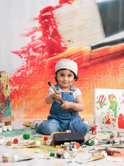 A proud artist with her creations. This shot captures her sense of accomplishment and the fun she had during the painting session.