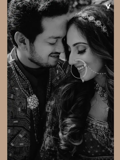 A tender black and white close-up of a couple, their faces touching, capturing a quiet moment of love and happiness. The intricate details of the bride's nath and jewelry add to the beauty of this Indian wedding portrait.