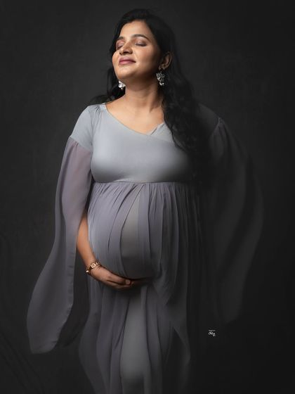 Serenity in shades of grey. The soft, flowing fabric of this gown adds a dreamy, ethereal quality to this moody and emotional solo maternity portrait.