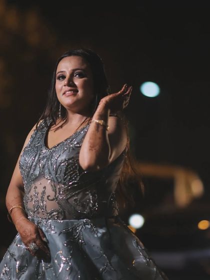 A beautiful outdoor portrait of the bride Gunjan at night. The soft focus on the background lights creates a lovely bokeh effect, making her the shining star of the image.