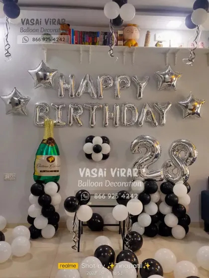 A classic and elegant setup for a 28th birthday. We used black, white, and silver balloons with star accents and a large champagne bottle foil balloon to create a sophisticated party corner.