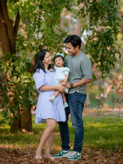 A lovely family portrait in the park, with their sweet daughter looking curiously at the camera. The soft, natural light of an outdoor photoshoot is always so flattering.