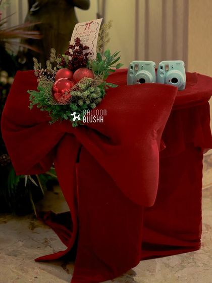A station for capturing memories, with instant cameras placed on a table draped in red velvet.