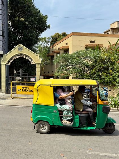 An auto-rickshaw passes the school entrance, a typical slice of Bengaluru life that forms the backdrop for our architectural work.
