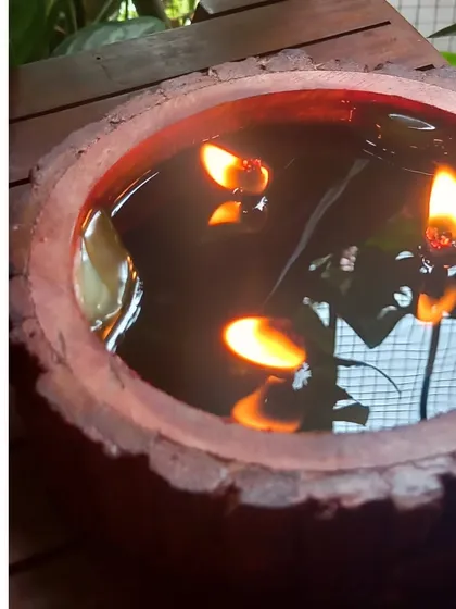 A lit wooden bowl candle, creating a beautiful floating effect with its multiple wicks. This piece was part of a custom order for wedding return favors, designed to bring a warm glow to the guests' homes.