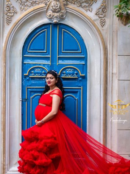 A bold and beautiful portrait in a vibrant red gown against a striking blue door. This studio setup is all about color and confidence.