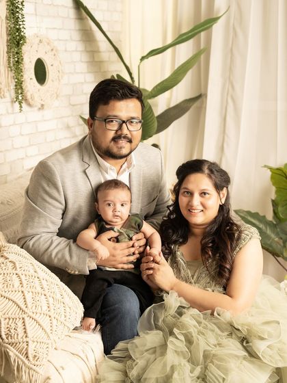 A comfortable and relaxed family portrait in a boho-chic studio setup. The soft textures and natural elements create a warm and inviting atmosphere.