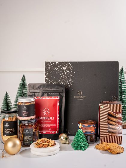 Our grand Christmas hamper is designed to wow. It's packed with a wide assortment of our best products, including biscotti, cookies, granola, nuts, and a festive candle, all presented in an elegant black box.