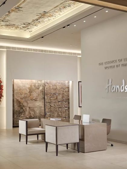 The Hands Carpets showroom in Mumbai, where a clean, minimalist design allows the vibrant and intricate carpets to be the heroes of the space. Natural light and neutral tones create a serene gallery-like atmosphere.