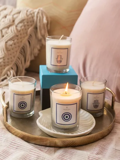 A collection of our Evil Eye and Hamsa candles arranged on a tray. These limited-edition soy candles are not just fragrant but also symbolic, making them a thoughtful gift for any occasion.