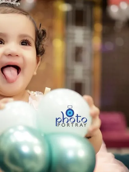 A playful close up of the birthday girl sticking her tongue out while holding balloons. My goal is to capture your child's personality in fun, candid portraits.