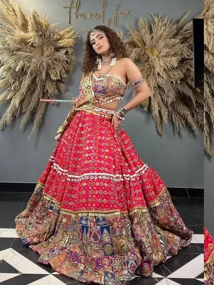 A vibrant red patchwork lehenga perfect for Navratri or a Mehendi function. The mix of prints and colors makes it a very energetic and eye-catching outfit.