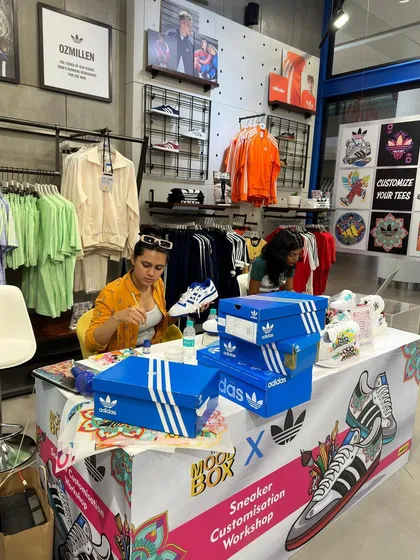Here I am in my element at the Adidas flagship store, setting up for a live sneaker customization workshop. This is what it looks like when I bring an interactive art station to an event, surrounded by paints, brushes, and fresh pairs of shoes ready for a makeover.