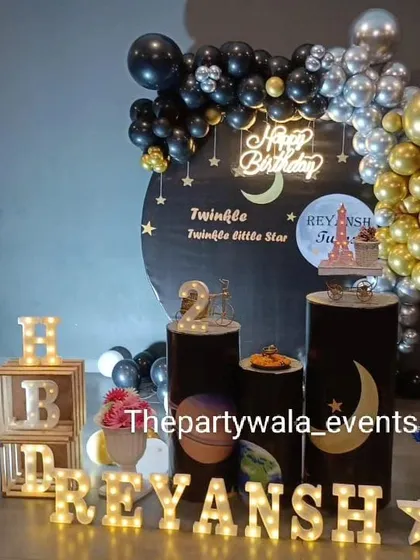 A "Twinkle Twinkle Little Star" theme with a black, silver, and gold color scheme. The moon and star props, along with the light-up name, create a magical starry night feel.