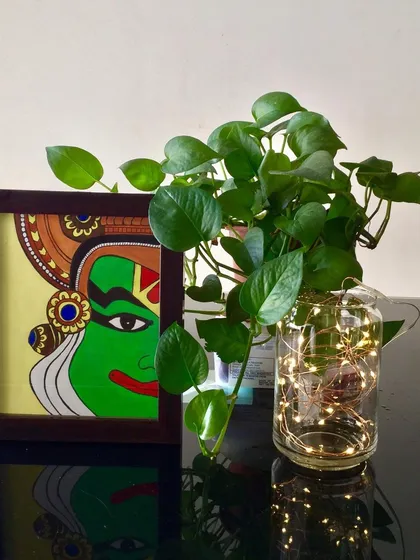 This is my tribute to the culture of Kerala, a Kathakali face painting. The striking green and intricate details represent the classic characters from this traditional dance form. It comes framed and ready to add a touch of drama to your wall.