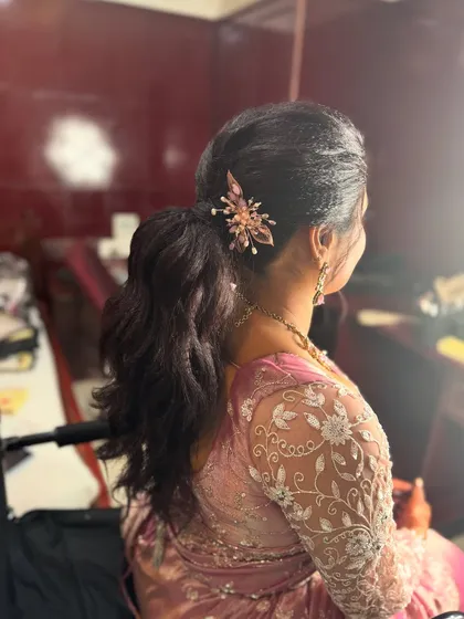 A view of the chic and modern hairstyle I created for Surya's reception. A textured, wavy ponytail adorned with a stylish hair accessory is the perfect choice for a contemporary bridal look.