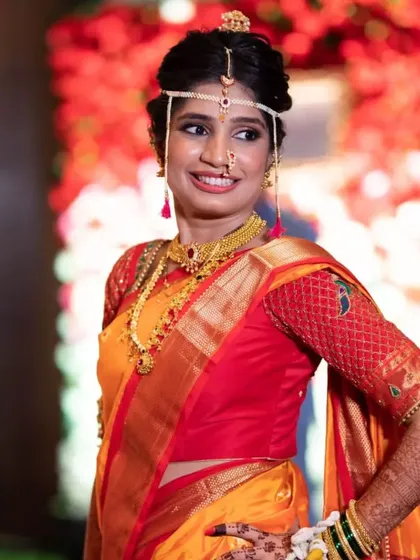 A full-length view of this bride's stunning yellow and red wedding saree. The makeup is balanced to complement the bright colors of her outfit, ensuring she looks radiant.