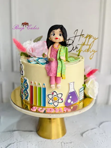 A special cake for a special teacher. I love creating personalized cakes that celebrate a person's profession, featuring custom fondant figures and details like the tiny books, science symbols, and colored pencils seen here.