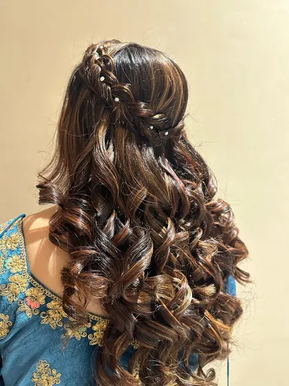 Big, bouncy curls with a braided crown, a glamorous choice for a sangeet or reception.