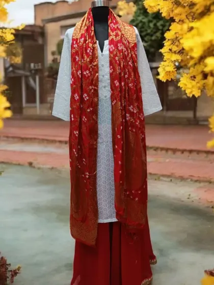 Another beautiful option for Holi, this time with a rich red bandhani dupatta. The classic combination of red and white is always a winner.