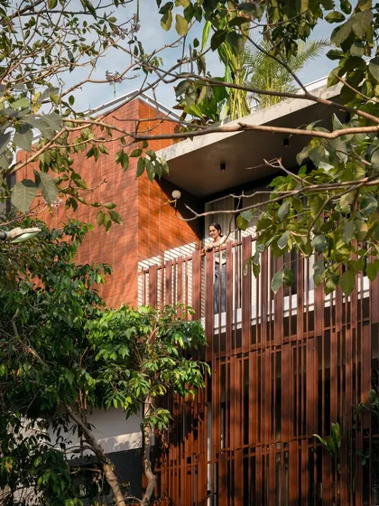 Peeking through the trees, the home's brick and metal facade feels integrated with the natural environment, showcasing our belief that architecture should complement, not dominate, nature.