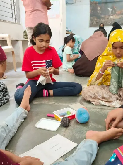 A group of girls sit together, deeply engaged in a sewing session. Our workshops create a calm and focused environment where kids can learn at their own pace and share tips with each other.