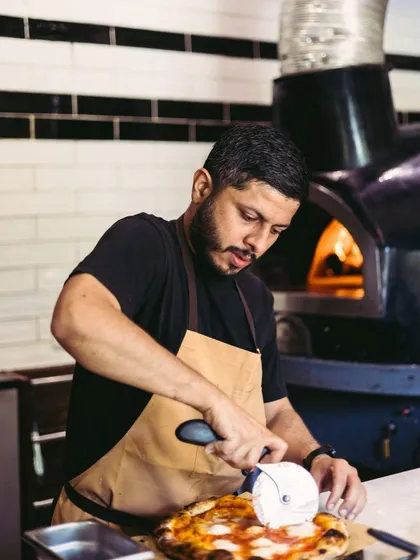 A little flour, a little fire, and a whole lot of love. Here I am, slicing up a fresh Neapolitan pizza, ready to be shared. This is my passion, bringing people together over good food.