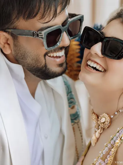 A fun and stylish close-up of Harshit and Kritika in sunglasses, their bright smiles showing their excitement.