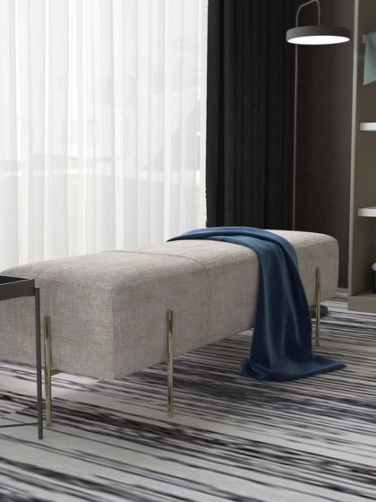 Elegant and minimalist, this modern bench is perfect for adding a touch of luxury to any space. It is seen here in a bedroom, complementing the modern decor.
