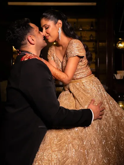 A tender and romantic moment during the cocktail party. This close-up shot highlights the couple's affection and the beautiful details of the bride's attire.
