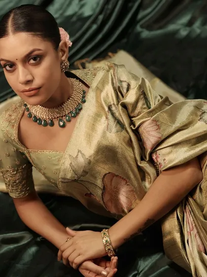 A full view of the soft green floral saree and custom embroidered blouse. The ensemble is perfect for a daytime wedding event or a sophisticated party.