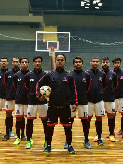 A futsal team poses for a powerful group photo before a match. Our arena provides an impressive backdrop that adds to the prestige of any tournament.