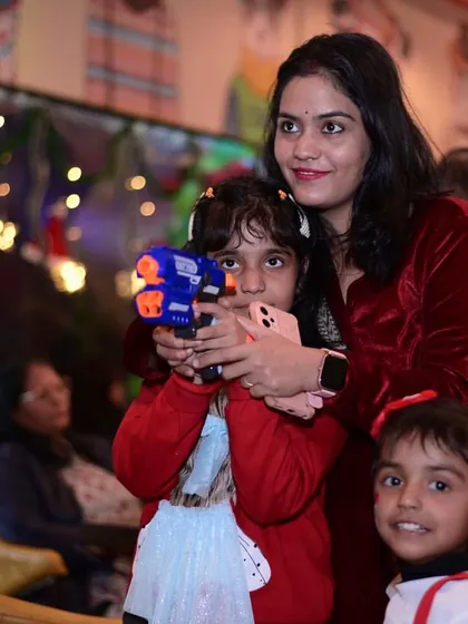 A mother helping her daughter with a toy gun at our Christmas event. It's all about interactive fun.