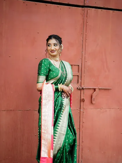 This is how royalty looks. For this Maharashtrian bride, we went with a classic look featuring a traditional green paithani saree, complemented by gold jewelry and a clean, elegant makeup look that honors her heritage.