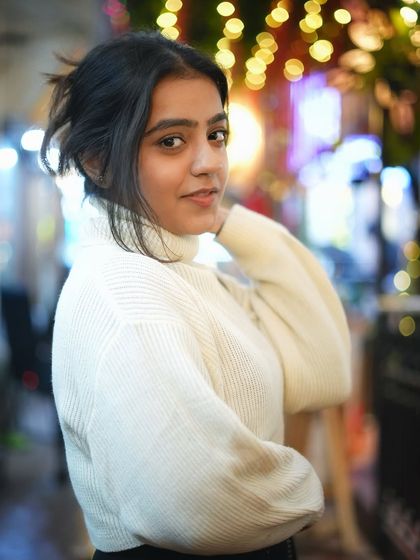 A classic winter portrait in a cozy turtleneck. Her profile and the soft background lights make this a very stylish and elegant night shot.