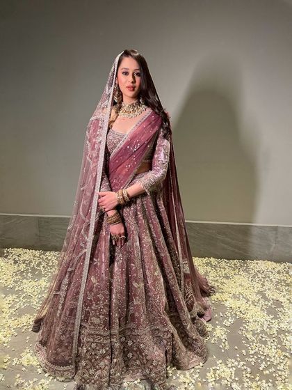 A full-length shot of a bride in a breathtaking lavender lehenga. The overall look is ethereal and incredibly elegant, perfect for a reception or sangeet.