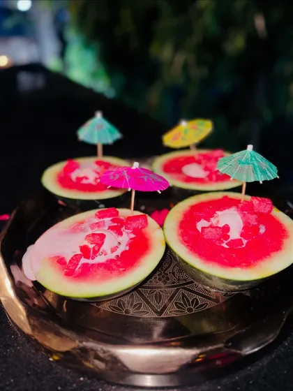 A refreshing and creative dessert, our watermelon ice cream is served in a hollowed-out watermelon rind and garnished with a cocktail umbrella. It's a playful and delicious treat that delights guests of all ages.