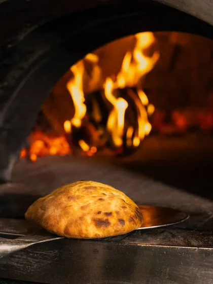 Embrace the taste of tradition with my freshly baked Ciabatta bread, puffed up and golden from the heat of the wood-fired oven.