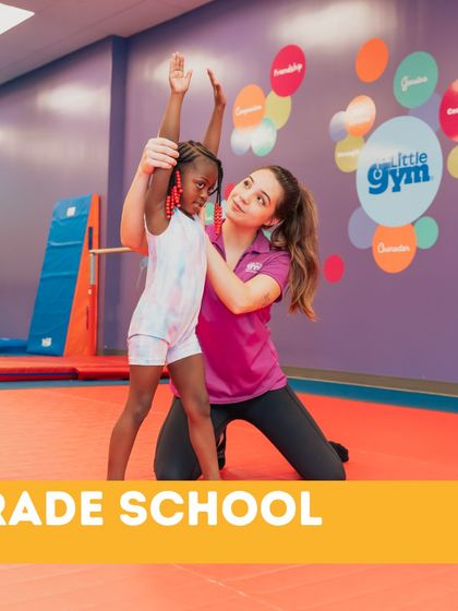 An instructor provides support as a young gymnast practices her form. Our grade school classes focus on both individual skill development and the importance of listening to and learning from our expert coaches.