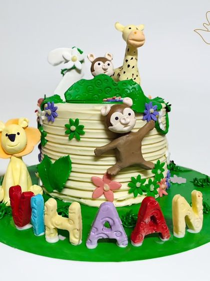 A fun and playful jungle cake for Vihaan's birthday. This design features a lion, monkey, and giraffe having a party in the jungle.